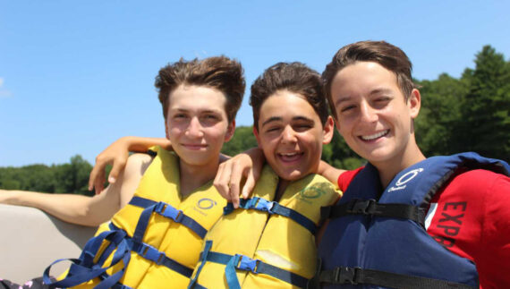 Three campers wearing life jackets.