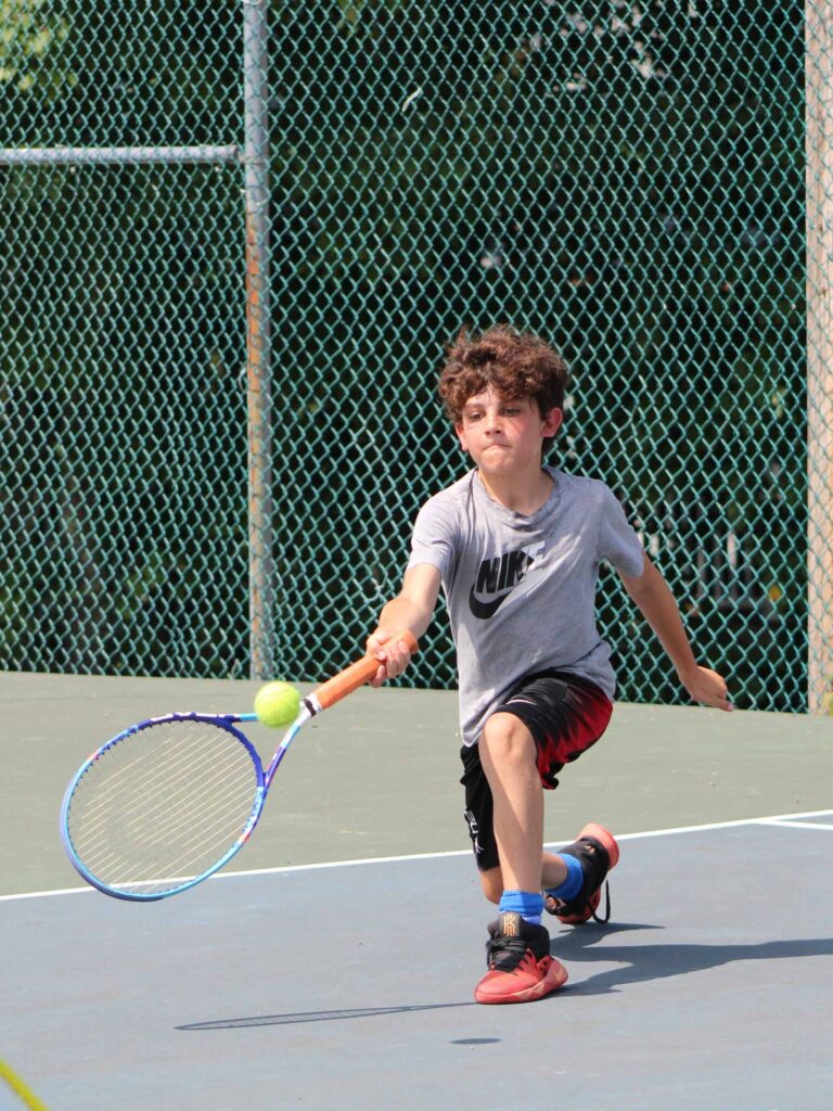A camper playing tennis.